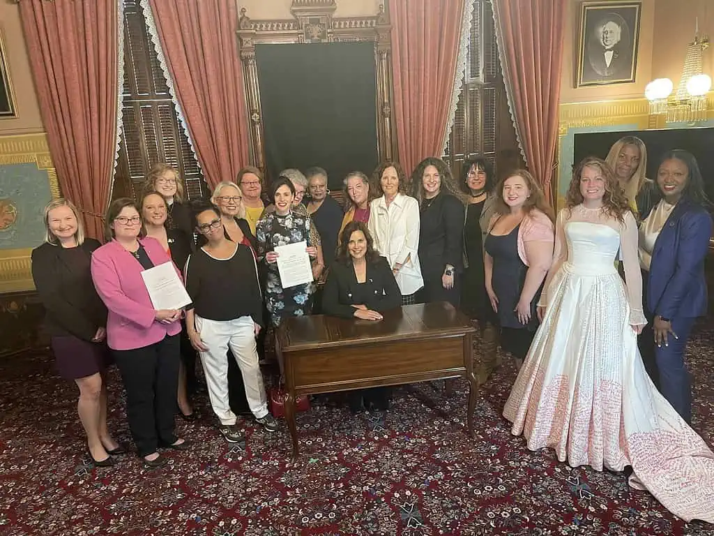 Unchained's founder/executive director, Fraidy Reiss, Unchained team members, allies in the Michigan Coalition to End Child Marriage and legislators -- including forced and child marriage survivors and Michigan state Sen. Sarah Anthony and Rep. Kara Hope -- gather around Michigan Gov. Gretchen Whitmer, who just ceremonially signed legislation to end child marriage in Michigan, 18 no exceptions. 